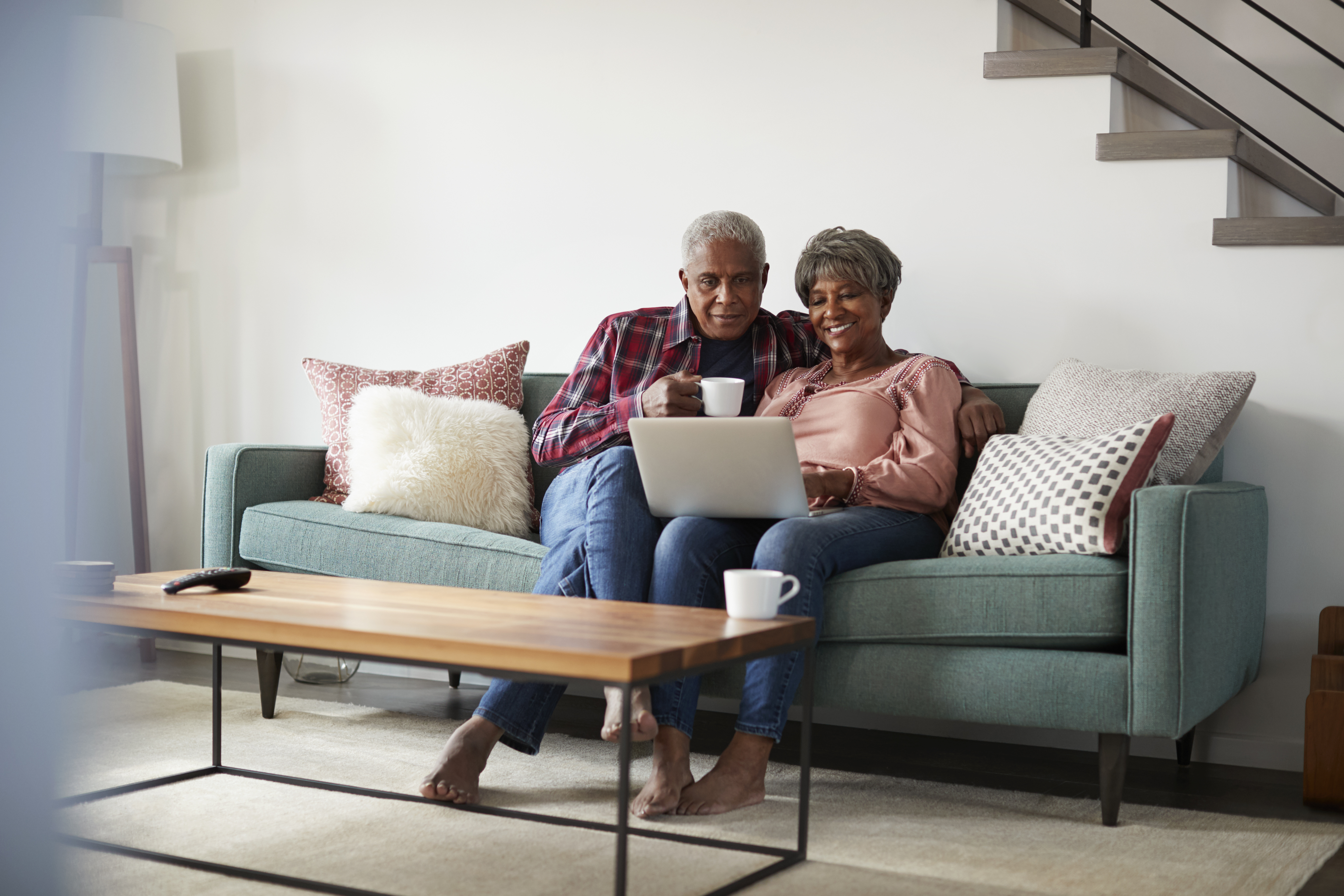 couple sitting in living room using their laptop